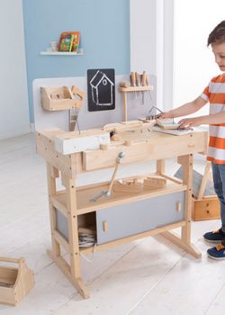 Junge spielt mit Holz Werkbank