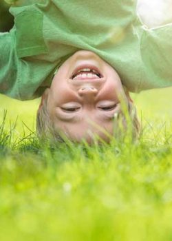 Kind macht Kopfstand im Gras